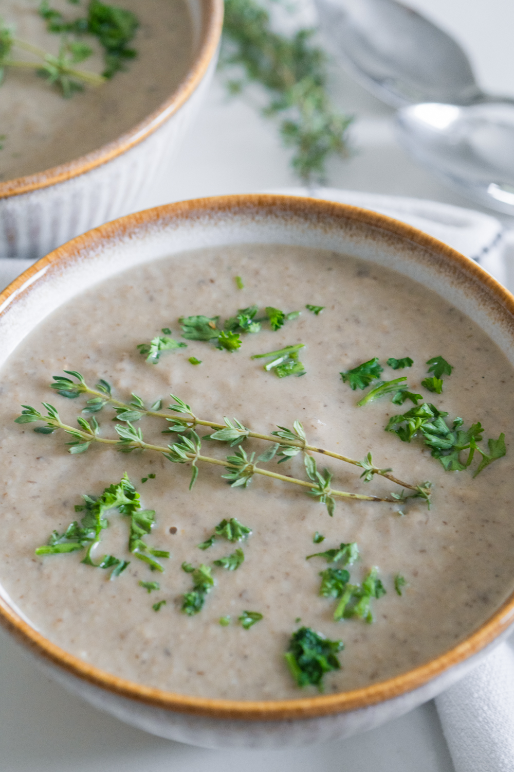 Vegan cream of mushroom soup in a bowel with thyme.