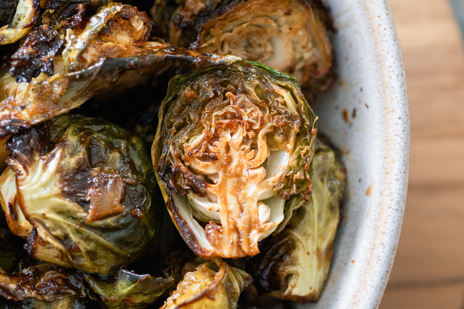 Caramelized Balsamic Brussels Sprouts in a white bowl on a cutting board.