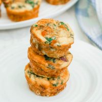 Three fall harvest egg muffins stacked on a white plate.