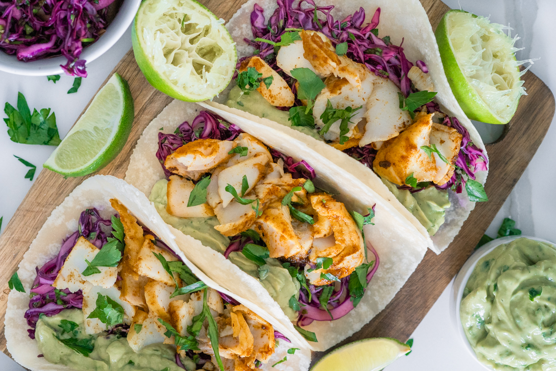 Spiced fish tacos with avocado cream and purple cabbage slaw in almond flour tortillas.