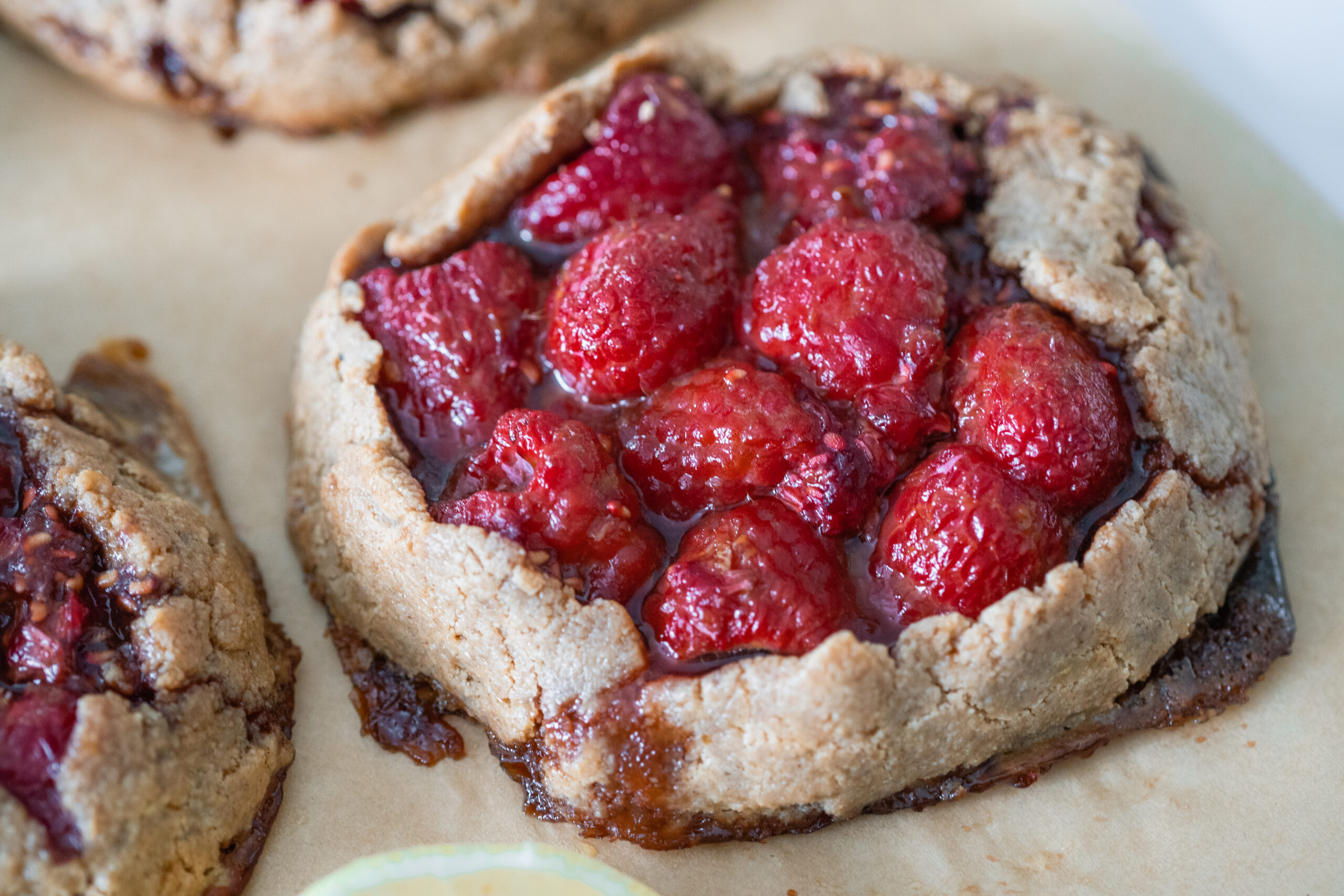 Raspberry lemon mini galette on parchment paper.