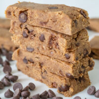 Cookie dough protein bars cut in rectangles and stacked on top of each other.