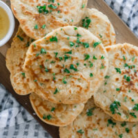 Healthy homemade gluten-free naan bread stacked on a cutting board.