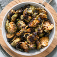 Caramelized Balsamic Brussels Sprouts in a white bowl on a cutting board.